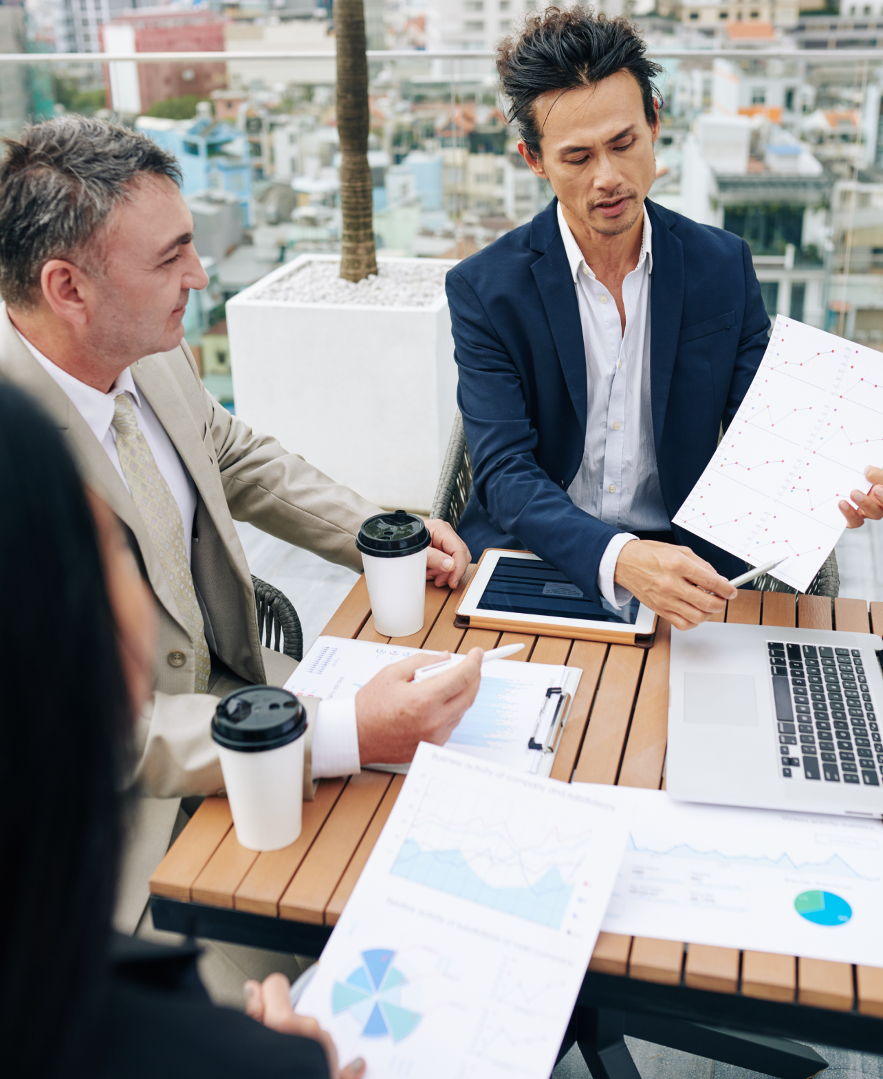 Business professionals reviewing financial charts in an outdoor meeting