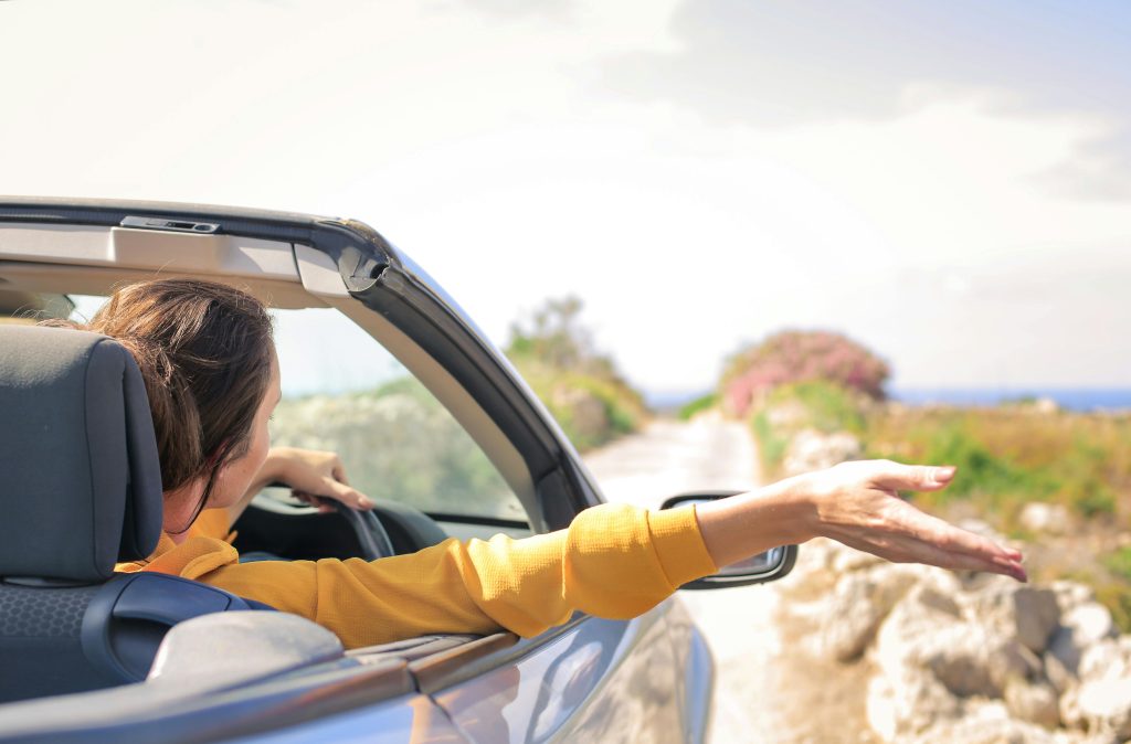 A woman wearing a yellow top drives with her arm out the window. I get pre approved for a car loan now what?